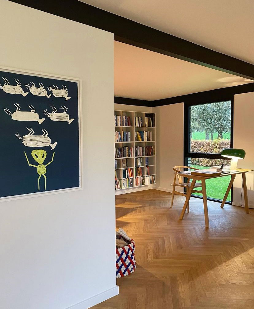 Hjemmekontoret har plads foran bogreolen. Brændekurv fra HAY og kunst af Frederik Næblerød.