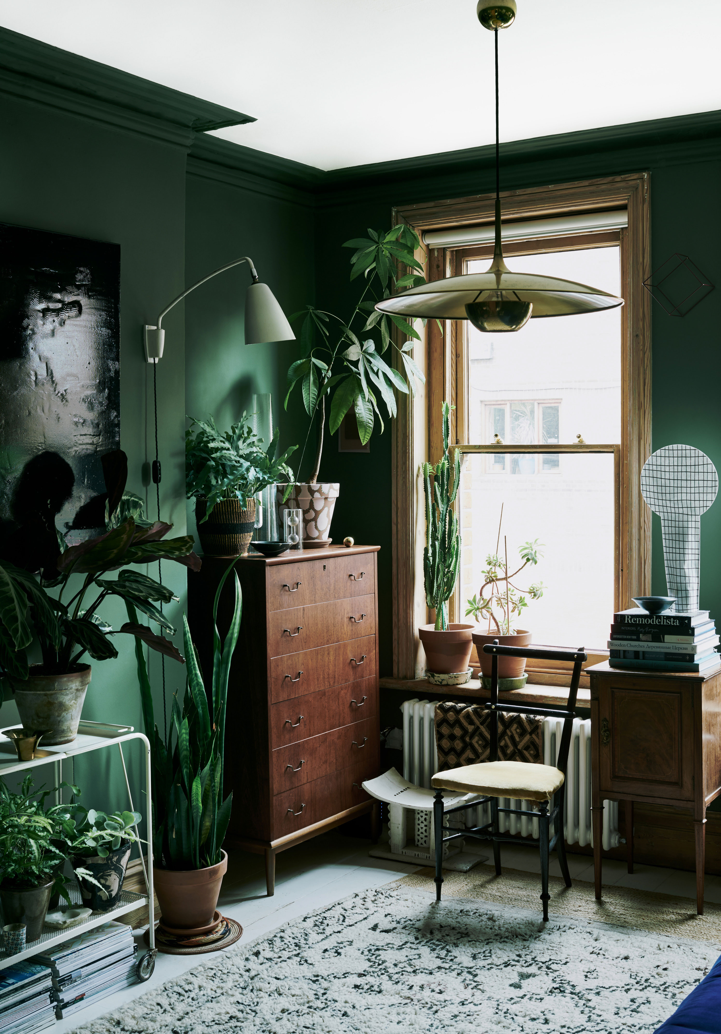 Man skal være modig for at male mørke farver på væggene, når man bor på 57 kvadratmeter, men det fungerer hos Laura. Lampen er designet af tyske Florian Schulz i 1960'erne. De øvrige møbler er loppefund.