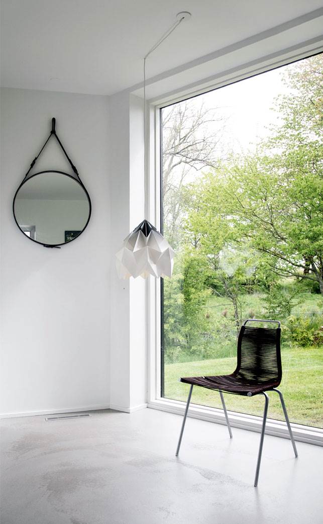 De store vinduesflader trækker naturen indenfor som her i entreen. Lampe fra studiosnowpuppe.nl og spejl fra Gubi.