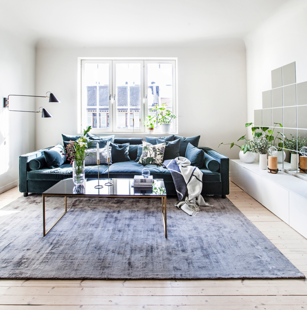 Stor veloursofa i stuen.