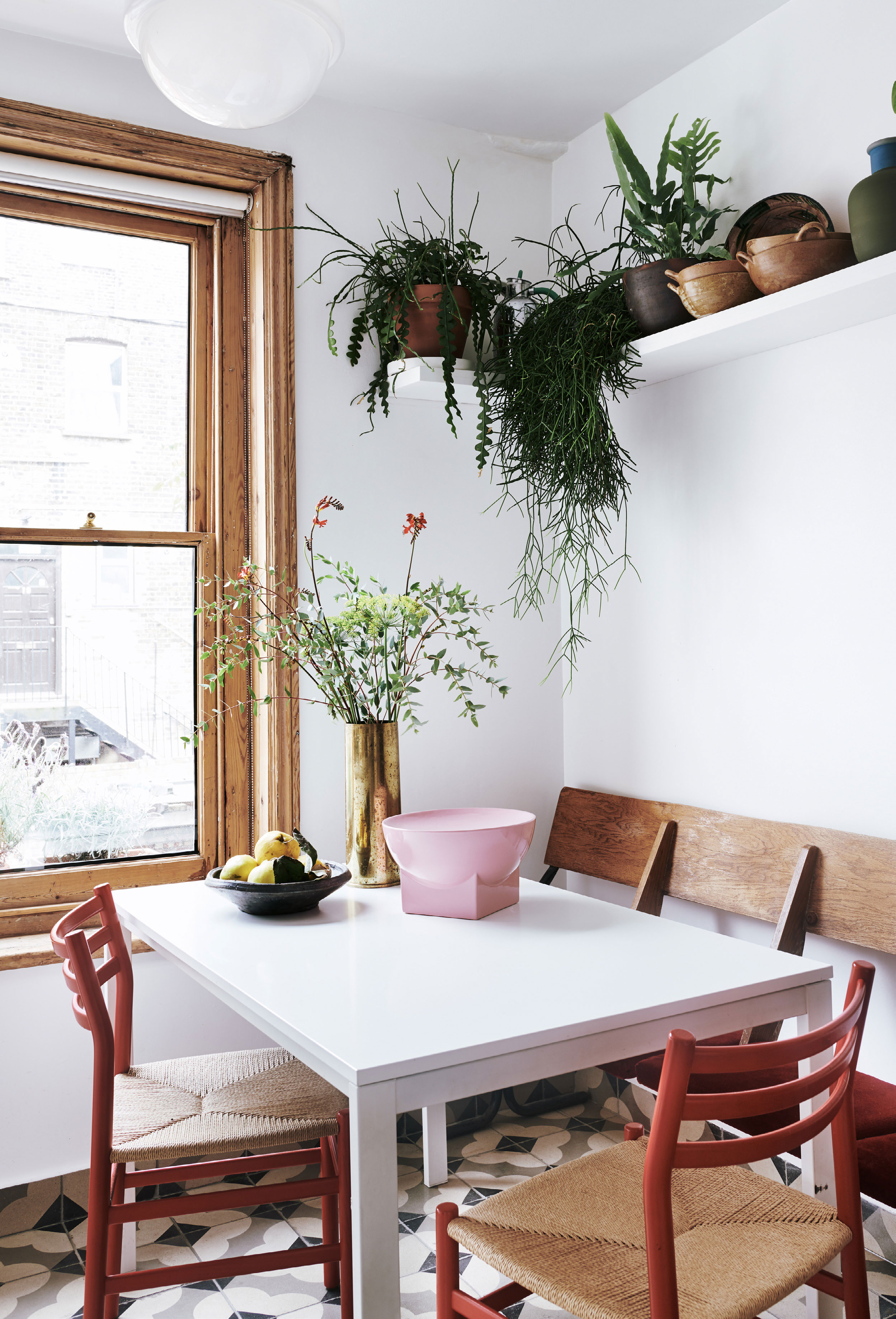 Fliserne på gulvet i køkkenet er fundet brugt og stammer oprindelig fra et kloster i Spanien. Bordet er fra Ikea og stolene fra en lokal møbelbutik. Vintagebænken med velourpolstring er et loppefund.