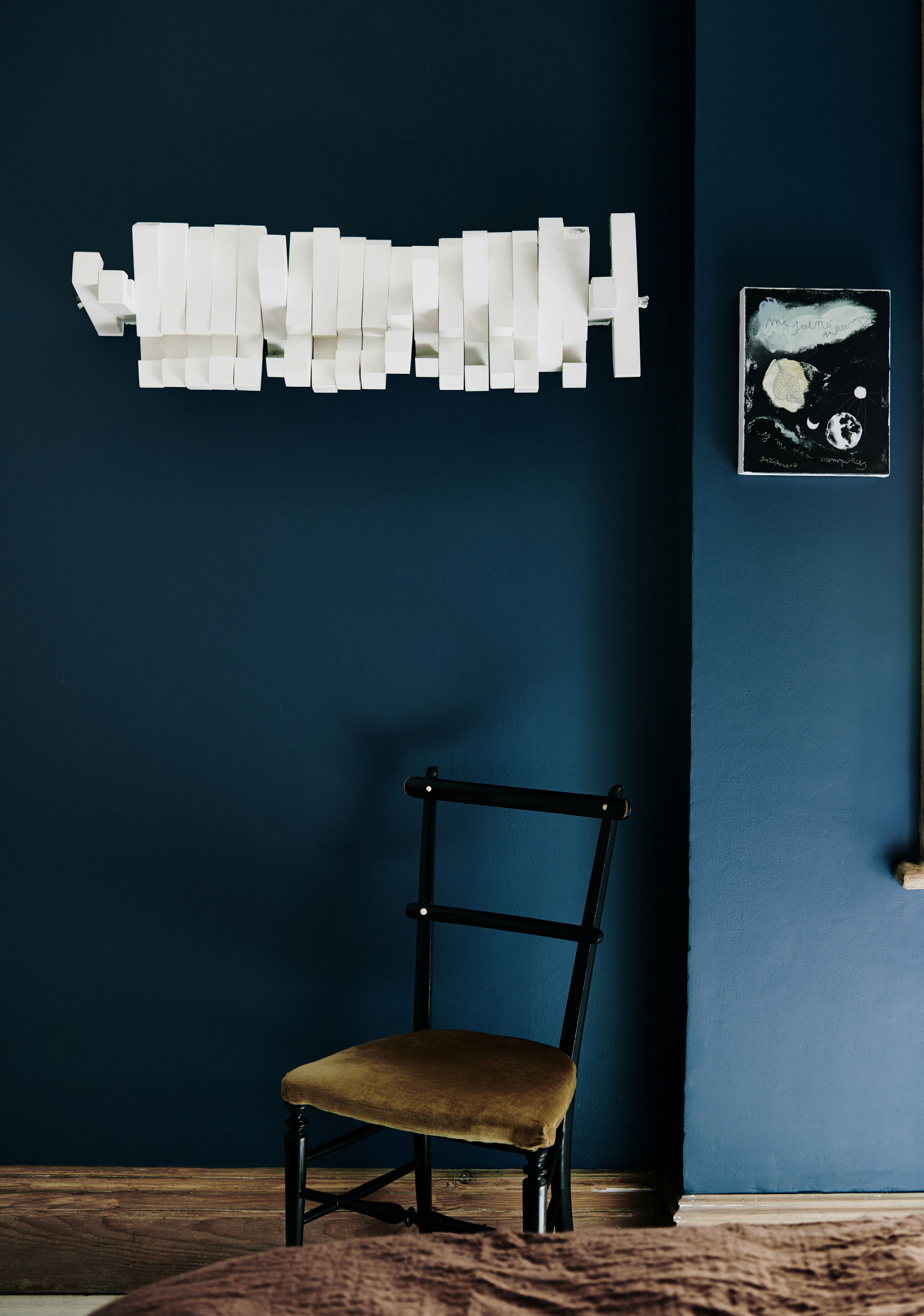 Soveværelset er malet en mørk støvet blå, der har en næsten søvndyssende effekt. Knagerækken på væggen er en prototype ,som Laura fandt på et galleri.