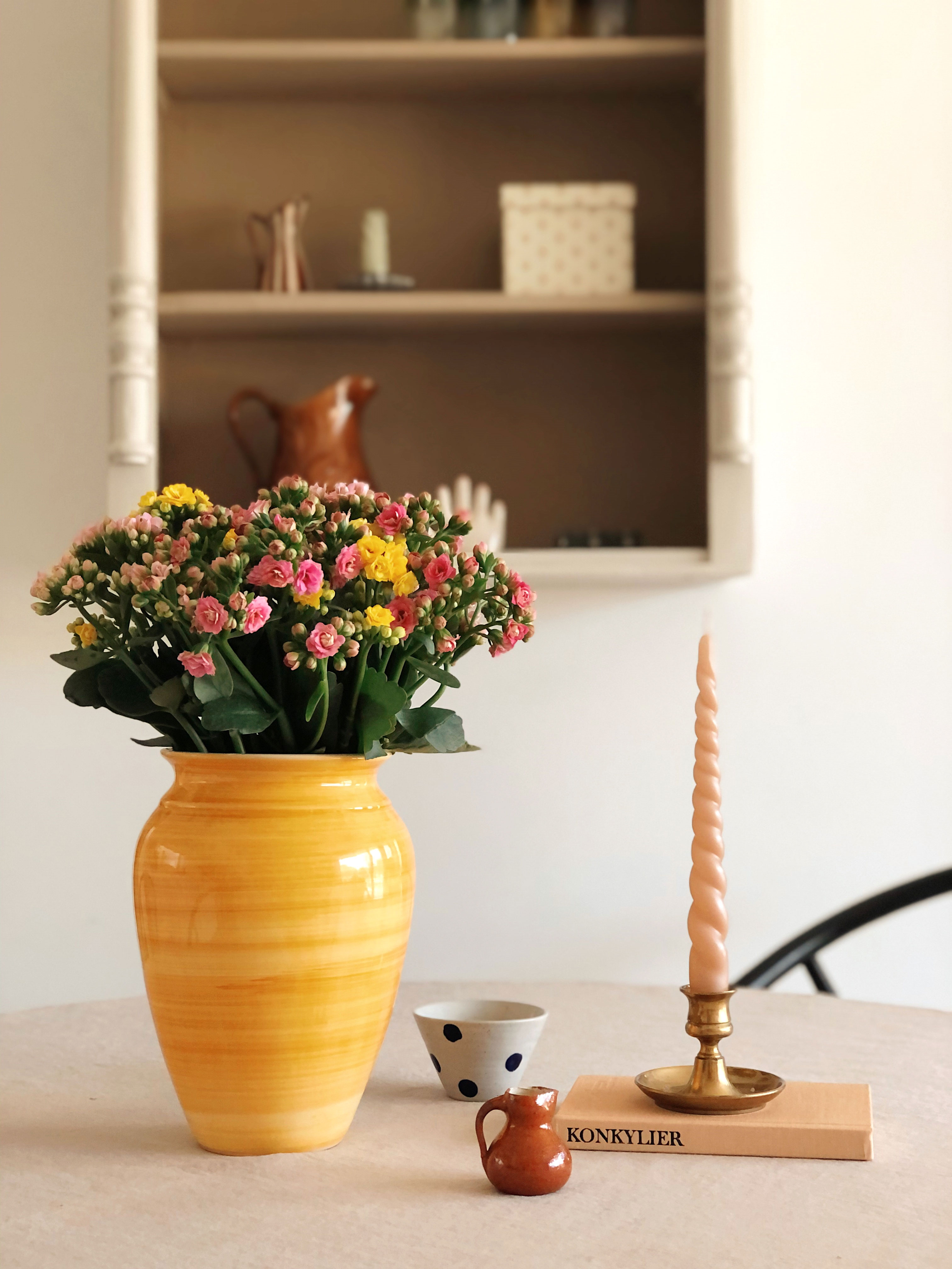 Farverige blomster fra Queenflowers i en solskinsgul vase til en flad 20’er fra Kirkens Korshær.