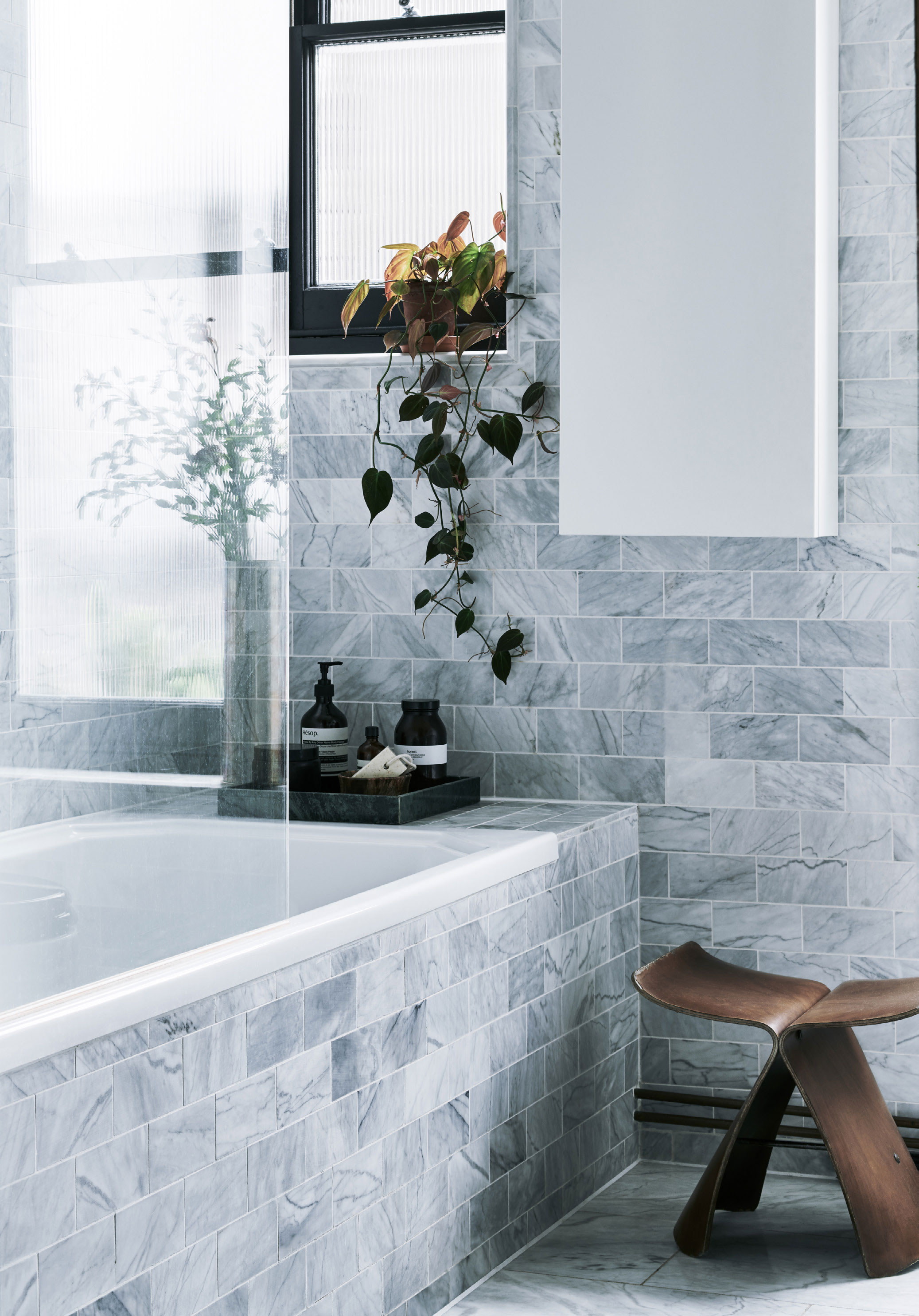 Badeværelset er beklædt med fliser fra Fired Earth på både gulv, vægge og badekar, hvilket skaber en dejlig harmoni. Sommerfugleskamlen er fra Vitra.