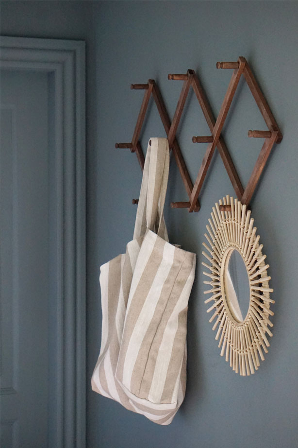Væggen i entreen er malet med fraven Serene Blue fra Jotun, knagerækken er fra Søstrene Grene, spejl fra H&M Home og net fra Compliments.